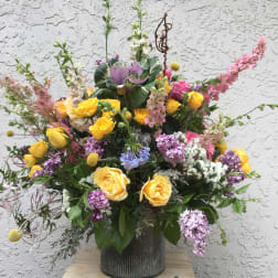 Large mixed bouquet of yellow and pink roses in a metal vase