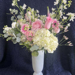 Pink and white floral arrangement in a tall white vase