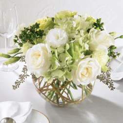 White and pale green floral centerpiece in a glass bowl vase