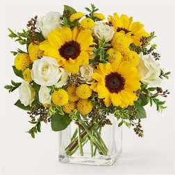 Yellow sunflowers and white roses arranged in a clear glass vase