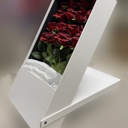 Red roses arranged in a white presentation box