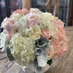 Bouquet of pale pink roses and white hydrangeas in a white container