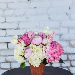 Pink and white flowers arranged in a terracotta pot