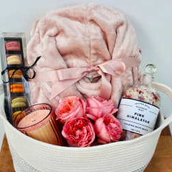 Gift basket with pink blanket, macarons, roses, candle, and bath salts