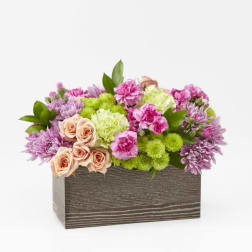 Pink and green flower arrangement in a rectangular wooden box