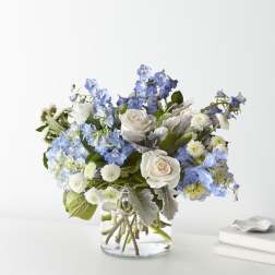 Blue and white flower arrangement in a clear glass vase