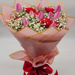 Pink tulips and red carnations in a wrapped bouquet