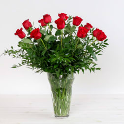 Red roses arranged in a clear glass vase