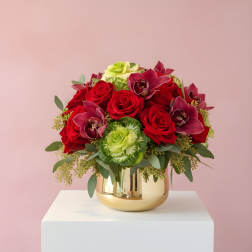 Red roses and burgundy orchids in a gold vase