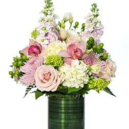 Arrangement of soft pink roses, orchids, and white hydrangeas in a green cylinder vase