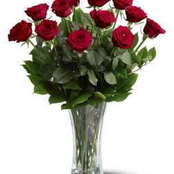 Red roses arranged in a clear glass vase