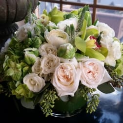 Bouquet of white and pale pink flowers in a green vase