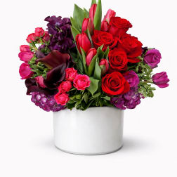 Red and purple bouquet in a white round box