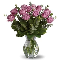 Lavender roses arranged in a clear glass vase