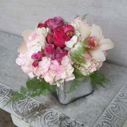 Pink and white bouquet with roses and orchids in a silver vase