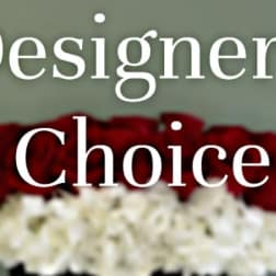 Red roses above a white floral arrangement with the words "Designer’s Choice" overlaid.