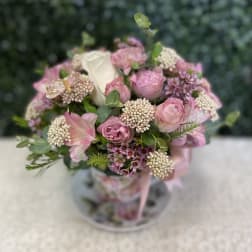 Pink and white bouquet with roses in a clear vase