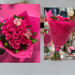 Bouquet of hot pink roses with a single pale orchid in embossed pink wrap.