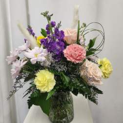 Mixed bouquet in a glass vase with purple, pink, yellow, and white flowers