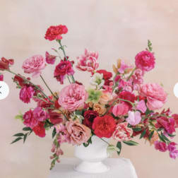 Pink and red mixed flower arrangement in a white vase