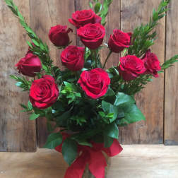 Bouquet of red roses in a clear glass vase with a red ribbon