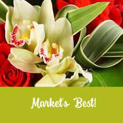 Close-up of red roses and pale green orchids with curled variegated leaves and a green banner reading Market's Best.