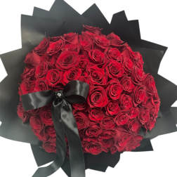Large bouquet of red roses wrapped in black paper with a black ribbon