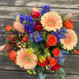 Colorful bouquet with gerbera daisies, roses, and blue flowers