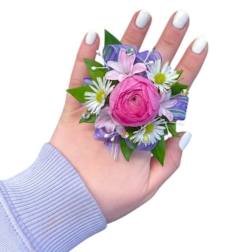 Pink floral corsage with white daisies on a hand
