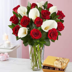 Bouquet of red roses and white calla lilies in a glass vase