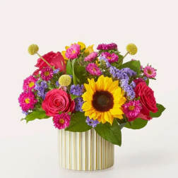 Mixed bouquet with sunflowers, roses, and purple flowers in a striped vase