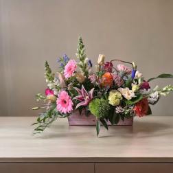 Mixed bouquet in a rectangular wooden box with pink and orange blooms