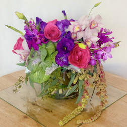 Bright pink and purple floral arrangement in a glass vase