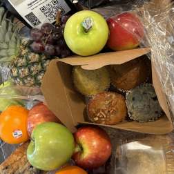 Fruit gift basket with apples, grapes, pineapple, muffins, and packaged coffee