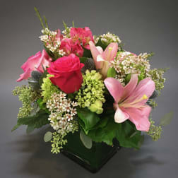 Pink and red mixed flower bouquet in a black vase