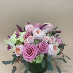 Pink and white rose arrangement in a dark vase