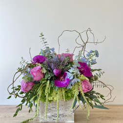Pink and purple floral arrangement in a rustic wooden box
