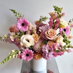 Pink and peach mixed bouquet in a white vase