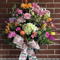 Large mixed flower arrangement with a floral ribbon bow