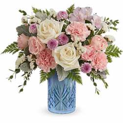 Pink and white flower arrangement in a blue glass vase
