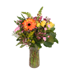 Mixed bouquet of orange, yellow, and pink flowers in a glass vase