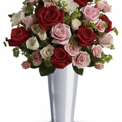 Bouquet of red, pink, and white roses in a tall silver vase