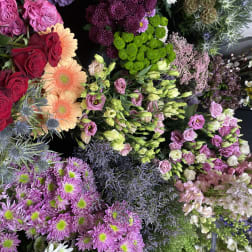 Assorted bouquets of roses, chrysanthemums, and gerbera daisies in bright colors