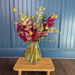 Mixed pink and magenta flowers in a clear glass vase