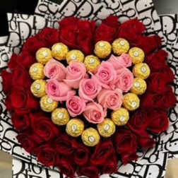 Heart-shaped bouquet of red and pink roses with gold chocolates