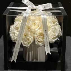 White roses arranged in a black gift box with a ribbon bow