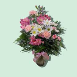 Pink and white mixed bouquet in a glass vase with a pink ribbon