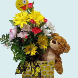 Bouquet of yellow, pink, and white flowers with a teddy bear and emoji balloon