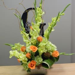 Tall floral arrangement with orange roses and lime-green gladiolus in a square vase