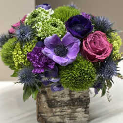 Bouquet of purple, pink, and green flowers in a birch-style box
